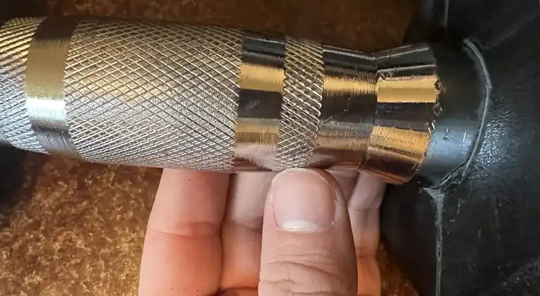 A knurling handle grip of CAP Barbell 150 Pound Dumbbell Set.
