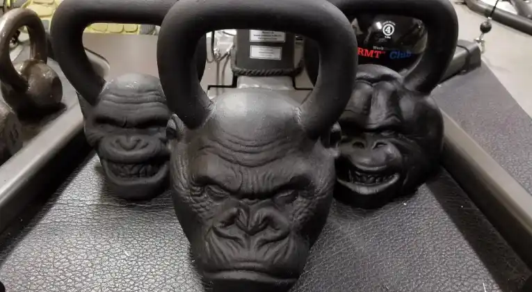  Three Onnit Primal kettlebells with sculpted gorilla faces on the handles.