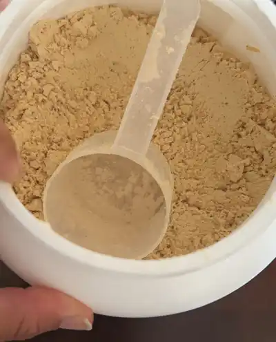 A spoon in Organifi Complete Protein powder to take off for pour.