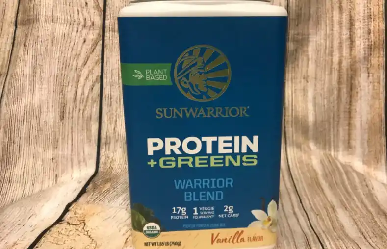 a box of the Sunwarrior protein and greens powder on a wooden table.